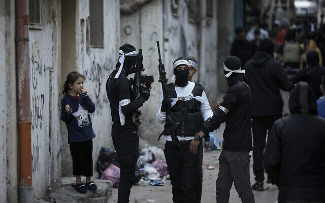 Illustration : Des Palestiniens masqués marchent dans Balata, le samedi 4 mars 2023. (Crédit : AP/Majdi Mohammed) Illustration : Des Palestiniens masqués marchent dans Balata, le samedi 4 mars 2023. (Crédit : AP/Majdi Mohammed)