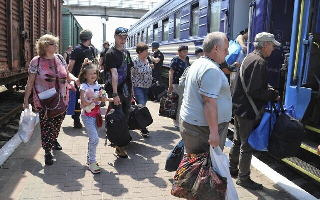 Des personnes montent à bord d'un train d'évacuation dans une gare de Kherson, en Ukraine, le 6 juin 2023, après la destruction d'un important barrage et d'une centrale hydroélectrique dans une partie du sud de l'Ukraine. (Crédit : AP Photo/Nina Lyashonok) Des personnes montent à bord d'un train d'évacuation dans une gare de Kherson, en Ukraine, le 6 juin 2023, après la destruction d'un important barrage et d'une centrale hydroélectrique dans une partie du sud de l'Ukraine. (Crédit : AP Photo/Nina Lyashonok)