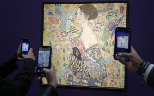 Des personnes prennent des photos de "Dame à l'éventail" de Gustav Klimt lors de son exposition dans les salles de vente de Sotheby's à Londres, le 20 juin 2023. (Crédit : AP/Kirsty Wigglesworth) Des personnes prennent des photos de "Dame à l'éventail" de Gustav Klimt lors de son exposition dans les salles de vente de Sotheby's à Londres, le 20 juin 2023. (Crédit : AP/Kirsty Wigglesworth)