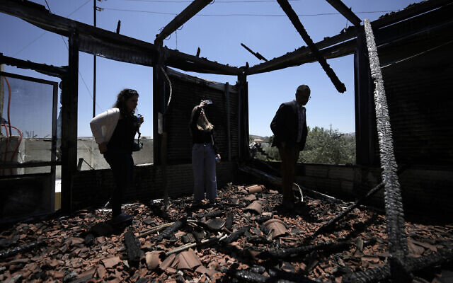 Une délégation regarde une maison incendiée pendant une visite de la ville de Turmus Ayya, en Cisjordanie, après un déchaînement de violences d'extrémistes du mouvement pro-implantation, le 23 juin 2023. (Crédit : AP Photo/Majdi Mohammed) Une délégation regarde une maison incendiée pendant une visite de la ville de Turmus Ayya, en Cisjordanie, après un déchaînement de violences d'extrémistes du mouvement pro-implantation, le 23 juin 2023. (Crédit : AP Photo/Majdi Mohammed)