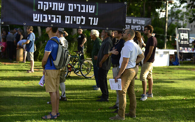 Evénement organisé par l’ONG de gauche "Briser le silence" à Tel-Aviv, le 1er juillet 2017, au cours duquel des témoignages de soldats précédemment stationnés en Cisjordanie ont été lus à haute voix devant la base militaire de Kirya. Le panneau dit : 'Briser le silence jusqu’à la fin de l’occupation.' (Crédit : Tomer Neuberg/Flash90) Evénement organisé par l’ONG de gauche "Briser le silence" à Tel-Aviv, le 1er juillet 2017, au cours duquel des témoignages de soldats précédemment stationnés en Cisjordanie ont été lus à haute voix devant la base militaire de Kirya. Le panneau dit : 'Briser le silence jusqu’à la fin de l’occupation.' (Crédit : Tomer Neuberg/Flash90)