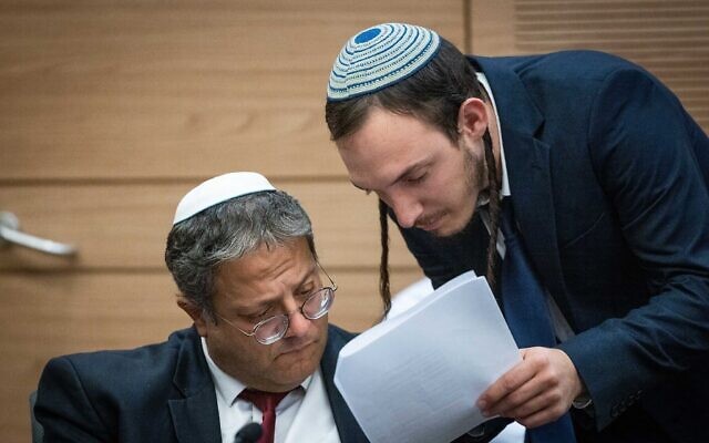 Le chef du parti Otzma Yehudit, Itamar Ben Gvir (à gauche) s'entretenant avec son chef de cabinet, Chanamel Dorfman, lors d'une réunion de la commission spéciale de la Knesset pour discuter des changements proposés à l'ordonnance sur la police, le 18 décembre 2022. (Crédit : Yonatan Sindel/Flash90) Le chef du parti Otzma Yehudit, Itamar Ben Gvir (à gauche) s'entretenant avec son chef de cabinet, Chanamel Dorfman, lors d'une réunion de la commission spéciale de la Knesset pour discuter des changements proposés à l'ordonnance sur la police, le 18 décembre 2022. (Crédit : Yonatan Sindel/Flash90)