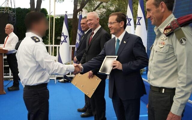 Le président Isaac Herzog décernant le Prix de la Défense d'Israël à un officier de la marine, aux côtés du chef de l'armée israélienne Herzi Halevi, à droite, et du ministre de la Défense Yoav Gallant, au centre, le 13 juin 2023. (Crédit : Ministère de la Défense)