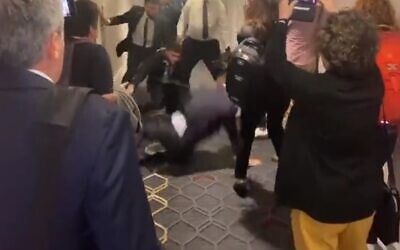 Un agent de sécurité accompagnant le ministre de l'économie Nir Barkat jetant un manifestant à terre, à Boston, le 8 juin 2023. (Crédit : Capture d'écran via Twitter ; utilisée conformément à la clause 27a de la loi sur le droit d'auteur).