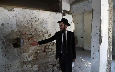 Le rabbin Israel Kozlovsky, directeur de Nariman Chabad House, montre les traces d'éclats d'obus laissées par les attaques terroristes de 2008, lors d'une visite à la presse à la veille du dixième anniversaire des attentats de Mumbai le 25 novembre 2018 (Crédit : PUNIT PARANJPE / AFP)