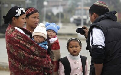 Un parent prend une photo de sa famille, membres de la communauté Bnei Menashe, en partance pour Israël à l'aéroport de Tulihal à Imphal, en Inde, le 20 décembre 2012. Illustration (Crédit : Anupam Nath/AP)