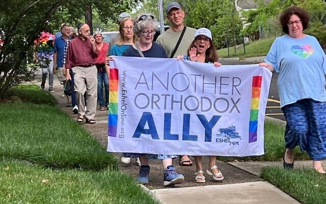 Des membres et des alliés d'Eshel, un groupe de défense des juifs orthodoxes LGBTQ et de leurs familles, défilent à Highland Park, dans le New Jersey, alors que les drapeaux de la Fierté sont rétablis dans une rue publique après avoir été retirés à la demande de rabbins orthodoxes, le 26 juin 2023. (Crédit : Autorisation d'Eshel/JTA) Des membres et des alliés d'Eshel, un groupe de défense des juifs orthodoxes LGBTQ et de leurs familles, défilent à Highland Park, dans le New Jersey, alors que les drapeaux de la Fierté sont rétablis dans une rue publique après avoir été retirés à la demande de rabbins orthodoxes, le 26 juin 2023. (Crédit : Autorisation d'Eshel/JTA)