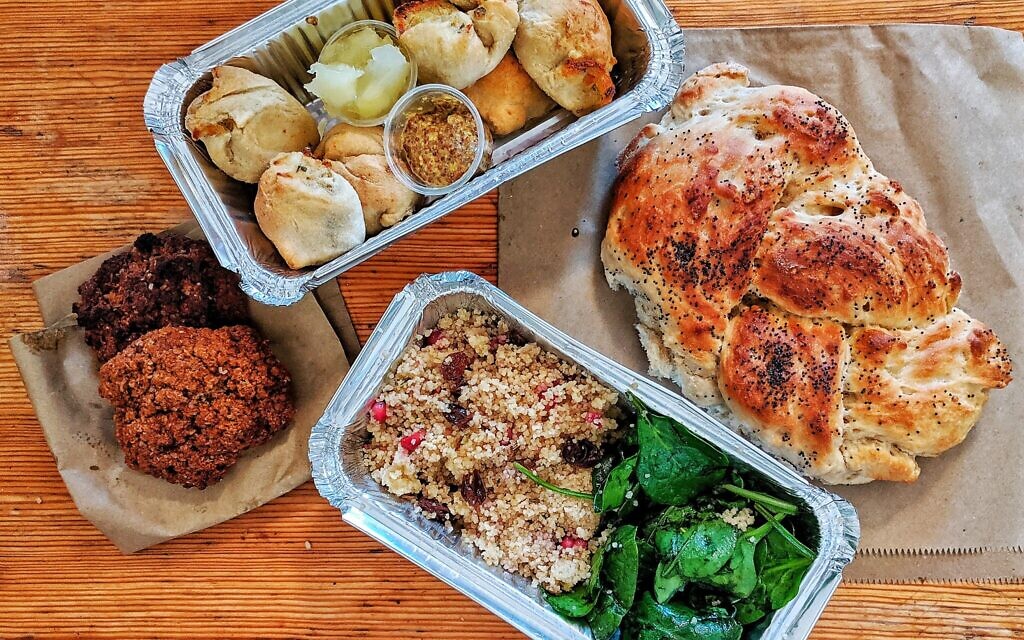 Une commande à emporter de knishes, de challah, de couscous et de biscuits. (Crédit : Pink Peacock/JTA)