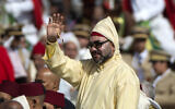 Le roi du Maroc Mohammed VI saluant la foule alors qu'il se tient dans une limousine, à l'occasion du 18ᵉ anniversaire de son accession au trône, lors d'une cérémonie d'allégeance, au palais du roi, à Tétouan, le 31 juillet 2018. (Crédit : AFP)