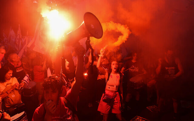 Des manifestants brandissant des bannières et des drapeaux lors d'un rassemblement à Tel Aviv pour protester contre le plan de réforme judiciaire du gouvernement, le 1er juillet 2023. (Crédit : Gil Cohen-Magen/AFP)