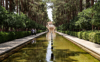 Un guide conduit des touristes au jardin Dowlat Abad dans la ville centrale de Yazd, en Iran, le 3 juillet 2023. (Crédit : ATTA KENARE / AFP)