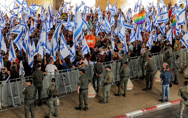 Des gardes-frontières se déployant autour d'une zone derrière des barrières désignées pour les manifestants anti-gouvernement, à l'aéroport Ben Gurion, le 11 juillet 2023. (Crédit : Jack Guez/AFP) Des gardes-frontières se déployant autour d'une zone derrière des barrières désignées pour les manifestants anti-gouvernement, à l'aéroport Ben Gurion, le 11 juillet 2023. (Crédit : Jack Guez/AFP)