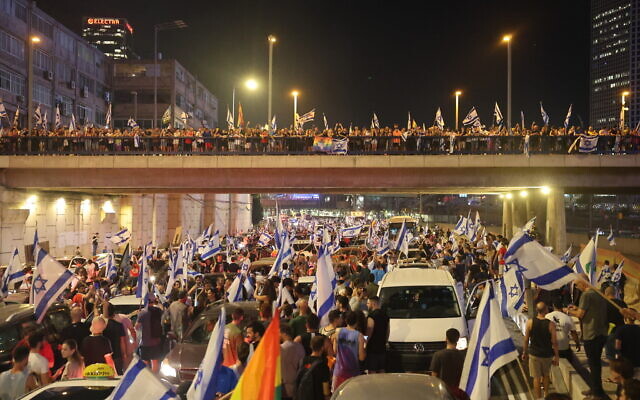 Des manifestants bloquant l'autoroute Ayalon au milieu de la circulation lors d'un rassemblement de protestation contre la refonte judiciaire du gouvernement, à Tel Aviv, le 24 juillet 2023. (Crédit : Jack Guez/AFP) Des manifestants bloquant l'autoroute Ayalon au milieu de la circulation lors d'un rassemblement de protestation contre la refonte judiciaire du gouvernement, à Tel Aviv, le 24 juillet 2023. (Crédit : Jack Guez/AFP)