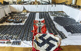 Cette photo fournie par le ministère autrichien de l'Intérieur le 29 juin 2023 montre des armes, des objets et des munitions sécurisés et des drapeaux flanqués de croix gammée. (Crédit : IMC/Gerd Pachauer via AP)