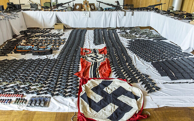 Cette photo fournie par le ministère autrichien de l'Intérieur le 29 juin 2023 montre des armes, des objets et des munitions sécurisés et des drapeaux flanqués de croix gammée. (Crédit : IMC/Gerd Pachauer via AP)