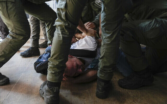 Des policiers israéliens arrêtent un manifestant lors d'une manifestation contre les plans du gouvernement du Premier ministre Benjamin Netanyahu visant à remanier le système judiciaire, à l'aéroport Ben Gurion, le lundi 3 juillet 2023. (Crédit : AP Photo/Ohad Zwigenberg)
