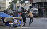 Des Palestiniens affrontant les forces de sécurité israéliennes lors d'un raid militaire dans la ville cisjordanienne de Naplouse, le 7 juillet 2023. (Crédit : AP Photo/Majdi Mohammed)