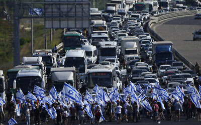 Des manifestants bloquent l'autoroute Tel Aviv-Haïfa près de Beit Yanai lors d'une manifestation contre la réforme judiciaire, le 11 juillet 2023 (Crédit : AP Photo/Ariel Schalit)