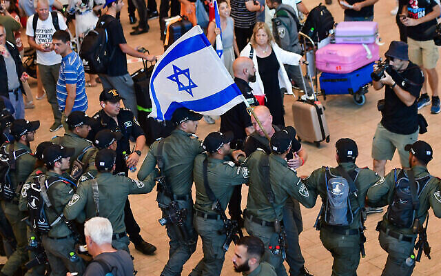 La police évacue les manifestants du hall d'arrivée lors d'une manifestation contre la refonte judiciaire voulue par le gouvernement israélien, à l'aéroport Ben Gurion près de Tel Aviv, le 3 juillet 2023. (Crédit : Avshalom Sassoni/Flash90)