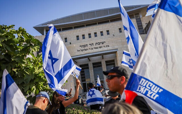 Des activistes protestant contre la réforme du système judiciaire prévue par le gouvernement, devant la yeshiva Har Hamor à Har Homa, à Jérusalem-Est, le 5 juillet 2023. (Crédit : Chaïm Goldberg/Flash90)