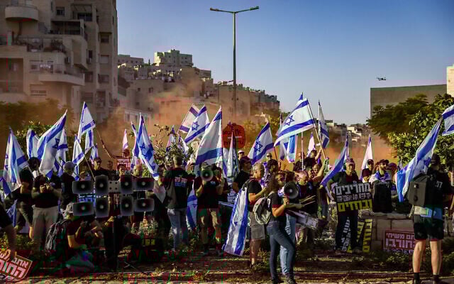 Des activistes protestant contre la réforme du système judiciaire prévue par le gouvernement, devant la yeshiva Har Hamor à Har Homa, à Jérusalem-Est, le 5 juillet 2023. (Crédit : Chaïm Goldberg/Flash90)