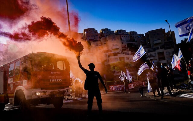 Des activistes protestant contre la réforme du système judiciaire prévue par le gouvernement, devant la yeshiva Har Hamor à Har Homa, à Jérusalem-Est, le 5 juillet 2023. (Crédit : Chaïm Goldberg/Flash90)