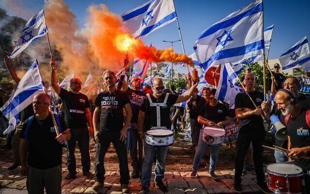 Des activistes protestant contre la réforme du système judiciaire prévue par le gouvernement, devant la yeshiva Har Hamor à Har Homa, à Jérusalem-Est, le 5 juillet 2023. (Crédit : Chaïm Goldberg/Flash90)