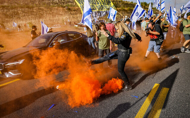 Des manifestants bloquant une route se heurtent à la police pendant une manifestation contre le plan de refonte du système judiciaire sir la Route 1, près de Ein Hemed, le 11 juillet 2023. (Crédit : Chaim Goldberg/Flash90)