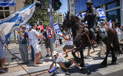 Un cheval piétine un manifestant lors d'un rassemblement contre le plan de refonte du système judiciaire à Tel Aviv, le 11 juillet 2023. (Crédit : Chaim Goldberg/Flash90)