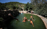 Des personnes profitant d'un chaud après-midi d'été, à la source Ein Lavan, à Jérusalem, le 23 juillet 2023. (Crédit : Jamal Awad/Flash90)