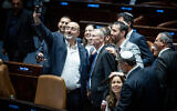 Les députés de la coalition autour du ministre de la Justice Yariv Levin pour prendre un selfie de célébration dans le plénum de la Knesset, après l'adoption de la première loi de refonte judiciaire de la coalition, le 24 juillet 2023. (Crédit : Yonatan Sindel/Flash90)