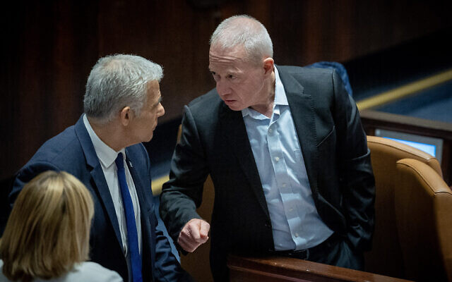 Le leader de l'opposition Yaïr Lapid, à gauche, et le ministre de la Défense Yoav Gallant assistant à un vote sur le projet de loi du "caractère raisonnable" à la Knesset, à Jérusalem, le 24 juillet 2023. (Crédit : Yonatan Sindel/Flash90) Le leader de l'opposition Yaïr Lapid, à gauche, et le ministre de la Défense Yoav Gallant assistant à un vote sur le projet de loi du "caractère raisonnable" à la Knesset, à Jérusalem, le 24 juillet 2023. (Crédit : Yonatan Sindel/Flash90)