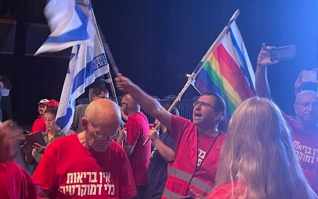 Le professeur Hagaï Levine, au centre, un des leaders des Blouses Blanches - Professionnels de santé pour la démocratie et chef de l'Association israélienne des médecins de santé publique, dirigeant les chants lors du rassemblement de protestation des médecins, à Jérusalem, le 23 juillet 2023. (Crédit : Renée Ghert-Zand/Times of Israel) Le professeur Hagaï Levine, au centre, un des leaders des Blouses Blanches - Professionnels de santé pour la démocratie et chef de l'Association israélienne des médecins de santé publique, dirigeant les chants lors du rassemblement de protestation des médecins, à Jérusalem, le 23 juillet 2023. (Crédit : Renée Ghert-Zand/Times of Israel)