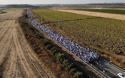 Des marcheurs, le long de la route 424, le 20 juillet 2023 au soir, sur le chemin du kibboutz Nahshon où ils ont passé leur troisième nuit, en route vers Jérusalem. (Crédit : Gitai Palti)