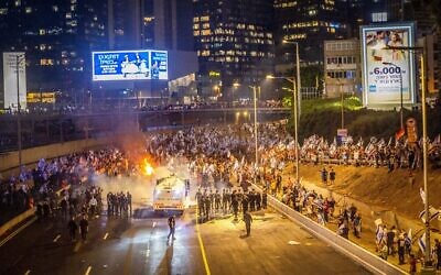 Des Israéliens bloquant l'autoroute Ayalon lors d'une manifestation contre la réforme judiciaire du gouvernement et en réaction à la destitution du chef du district de Tel Aviv, Amichaï Eshed, à Tel Aviv, le 5 juillet 2023. (Crédit : Yossi Aloni/Flash90)