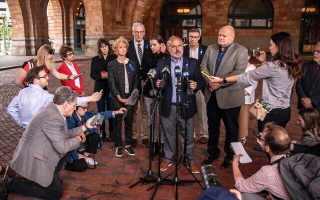 Le PDG de la Fédération juive de Pittsburgh, Jeff Finkelstein, s'adressant à la presse après qu'un jury a déclaré le tireur qui a abattu 11 fidèles juifs coupable de crimes fédéraux. Le journaliste de la JTA est agenouillé en bas à gauche, à Pittsburgh, le 16 juin 2023. (Crédit : Alexandra Wimley/Pittsburgh Union Progress via Pittsburgh Jewish Chronicle via JTA)