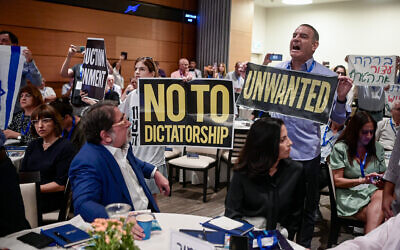 Des manifestants opposés à la refonte judiciaire protestant contre la présence du ministre de l'Économie Nir Barkat lors d'une conférence, à la Bourse de Tel Aviv, le 10 juillet 2023. (Crédit : Avshalom Sassoni/Flash90)