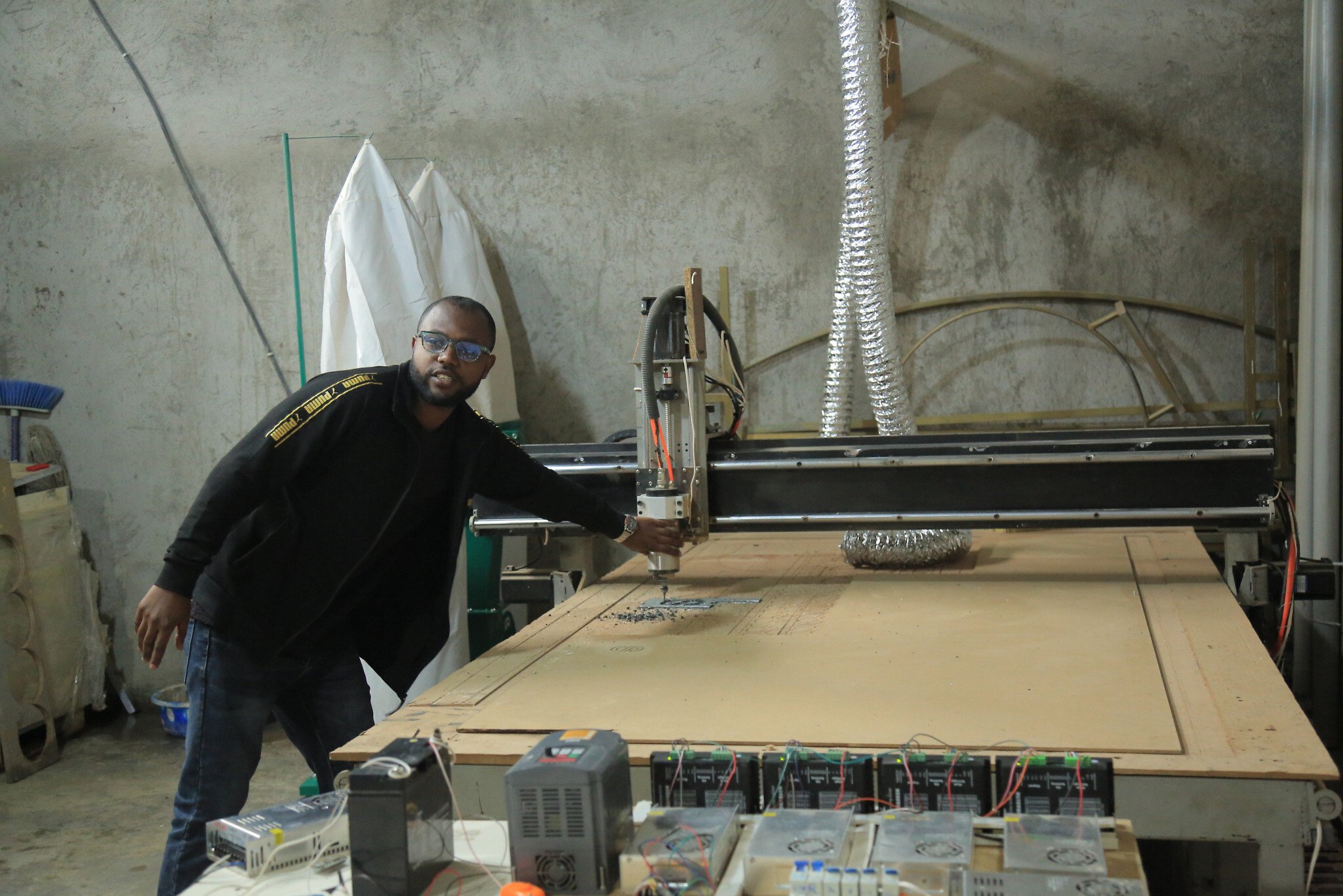 Biniam Dereie, un développeur de nouveaux logiciels pour faire fonctionner un prototype de machine à commande numérique par ordinateur qu'ils ont construit, Addis Abebe, juillet 2023. (Crédit : Amanda Borschel-Dan/ToI)