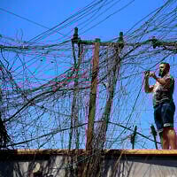 Muqtada Haider tourne les interrupteurs pour transférer l'électricité aux maisons privées à Bagdad, Irak, vendredi 10 septembre 2021. (Crédit : Hadi Mizban/AP)