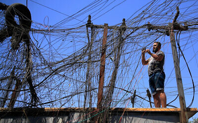 Muqtada Haider tourne les interrupteurs pour transférer l'électricité aux maisons privées à Bagdad, Irak, vendredi 10 septembre 2021. (Crédit : Hadi Mizban/AP)