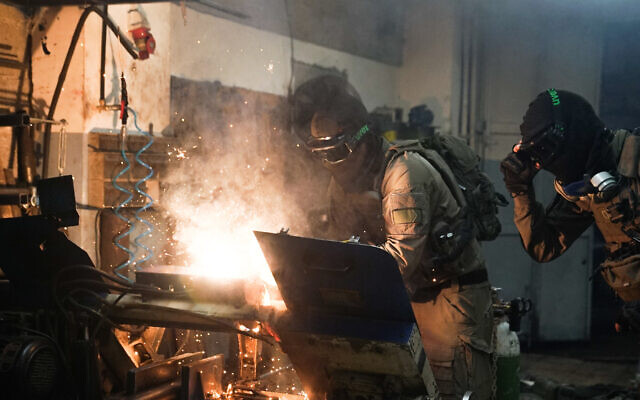 Des soldats israéliens détruisent des tours dans un atelier de fabrication d'armes palestinien dans la ville de Beitunia en Cisjordanie, le 31 août 2023. (Crédit : Police israélienne) Des soldats israéliens détruisent des tours dans un atelier de fabrication d'armes palestinien dans la ville de Beitunia en Cisjordanie, le 31 août 2023. (Crédit : Police israélienne)