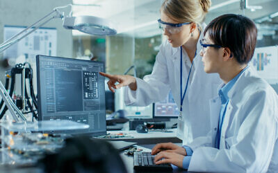 Illustration : Un scientifique assis à son bureau et consultant un ingénieur sur le codage et la programmation sophistiqués dans un laboratoire de recherche en informatique. (Crédit : iStock by Getty Images)