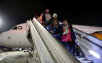 Des réfugiés ukrainiens et de nouveaux immigrants débarquent d'un avion à leur arrivée à l'aéroport israélien Ben Gourion, près de Tel Aviv, le 22 décembre 2022. (Crédit : Gil Cohen-Magen / AFP)