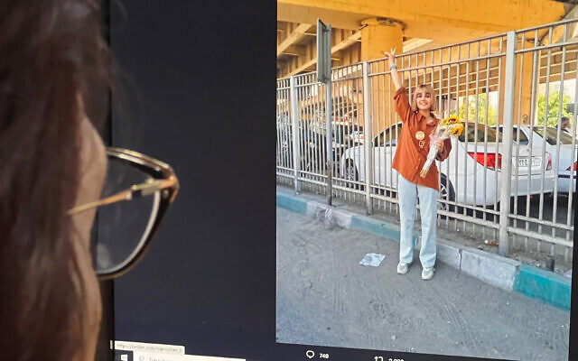 Une femme à Nicosie, la capitale chypriote, regarde un écran affichant une image postée sur le compte de la plateforme X (anciennement Twitter) de la journaliste iranienne Nazila Maroufian, le 13 août 2023, montrant apparemment le signe de la victoire après sa libération de la prison d'Evin à Téhéran. (Crédit : Alex MITA / AFP) Une femme à Nicosie, la capitale chypriote, regarde un écran affichant une image postée sur le compte de la plateforme X (anciennement Twitter) de la journaliste iranienne Nazila Maroufian, le 13 août 2023, montrant apparemment le signe de la victoire après sa libération de la prison d'Evin à Téhéran. (Crédit : Alex MITA / AFP)