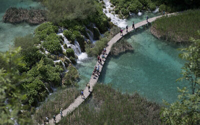 Illustration : Des touristes traversant un pont dans le parc national de Plitvice, dans le centre de la Croatie, le 21 juin 2013. (Crédit : Darko Bandic/AP Photo)