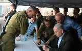 Le Premier ministre Benjamin Netanyahu et le ministre de la Défense  Yoav Gallant, à droite, sur les lieux d'une attaque terroriste à l'arme à feu près de Hébron, en Cisjordanie, le 21 août 2023. (Crédit :  Amos Ben Gershom/GPO)