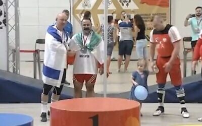 Mostafa Rajaei, à droite, serrant la main de l'haltérophile israélien Maksim Svirsky lors d'un championnat du monde des maîtres à Wieliczka, en Pologne, le 26 août 2023 (Crédit : Capture d'écran X ; utilisée conformément à l'article 27a de la loi sur le droit d'auteur).