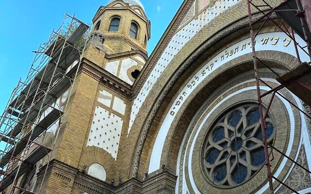 Des échafaudages entourent la façade de la synagogue de Novi Sad, en Serbie, qui est en train d'être rénovée. (Crédit : Larry Luxner/JTA)