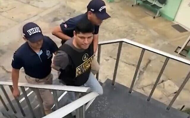 Eddie Manuel Nunez Santos, 33 ans, qui a envoyé une série d'alertes à la bombe à des institutions américaines, y compris des synagogues est escorté par la police péruvienne, à Lima, au Pérou, le 26 septembre 2023. (Crédit : Capture d'écran de la vidéo Twitter : utilisée conformément à la clause 27a de la loi sur les droits d'auteur) Eddie Manuel Nunez Santos, 33 ans, qui a envoyé une série d'alertes à la bombe à des institutions américaines, y compris des synagogues est escorté par la police péruvienne, à Lima, au Pérou, le 26 septembre 2023. (Crédit : Capture d'écran de la vidéo Twitter : utilisée conformément à la clause 27a de la loi sur les droits d'auteur)