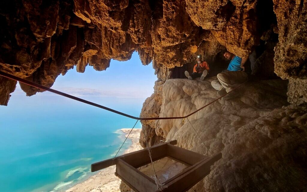 Des archéologues travaillant à l'excavation de la grotte où quatre épées romaines ont été découvertes dans le désert de Judée, avec vue sur la mer Morte. (Crédit : Oriya Amichai/IAA)